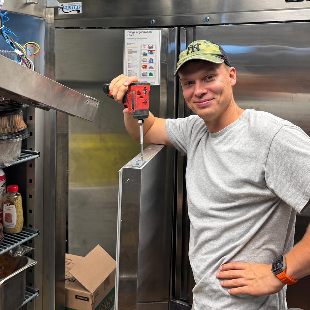 Technician diagnosing commercial refrigerator temperature problem